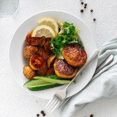 Dinner plate with vegetarian food. Fresh vegetarian cutlets with new potatoes and salad on white...