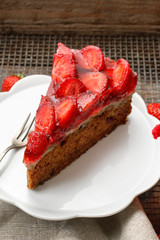 Piece of strawberry cake on white ceramic cake stand.