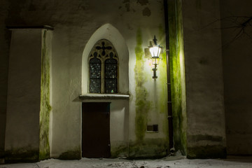 Fototapeta na wymiar The door and window on the historic wall of Cathedral of Saint Mary the Virgin in Tallinn at night. Estonia