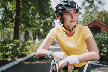 Beautiful smiling woman is riding bicycle outdoors