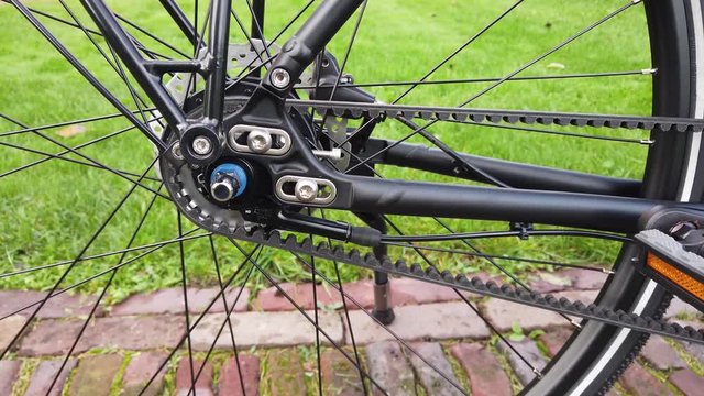Close up footage of modern and brand new rear setup configuration of parked cycle panning right camera view showing the mechanical belt drive and further components on the vehicle 4k high resolution