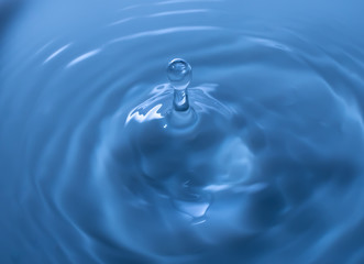 Water drop falling and drips on mirror. Water drop splash and make perfect circles on water surface.