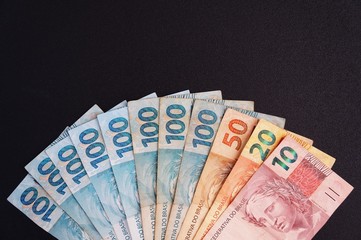 Brazilian money on black background. Real. Brazilian currency. 