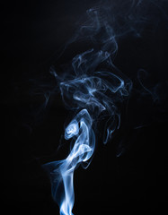 Smoke the blue incense on a black background. darkness concept
