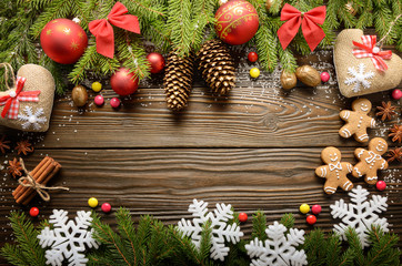 Flat lay Christmas border background of twigs, baubles, gingerbread cookies and spices with copy-space