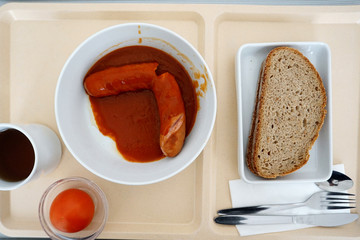 Tasty currywurst with french fries served in a beer garden for immediate consumption