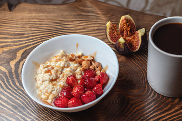 Breakfast oatmeal porridge with fruits berries and coffee cup. Healthy breakfast concept.