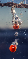 Tomates entrando en agua burbujas