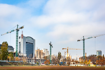 Fototapeta na wymiar Tower cranes work on the construction of buildings.