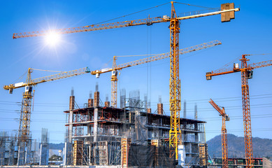 Workers are working on large construction sites and many cranes are working in the construction industry.