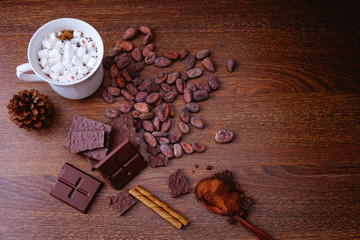 Hot cocoa with chocolate bars and powdered chocolate On a wooden background