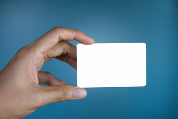 Obraz premium Hand holding a blank piece of paper. Close up white business card.