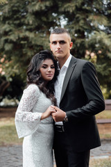 Couple in love - beginning of a love story. A man and a girl in the park. Beautiful pre-wedding photo of the bride and groom. Young couple show love for each other, a holiday