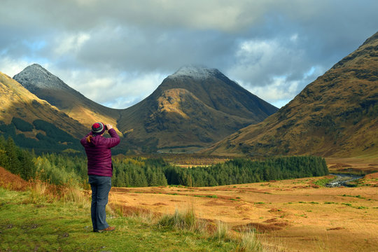 Woman (not recognisable) taking cellphone photo in Glen Etive Scottish Highlands
