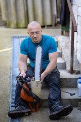 Sharpening a chainsaw Close up on a man sharpening a chainsaw chain with file