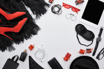 top view of dress, heels, gadget, gift boxes, sleeping mask, sunglasses, perfume, wristwatch, earrings, earphones, bracelets, bag, hat