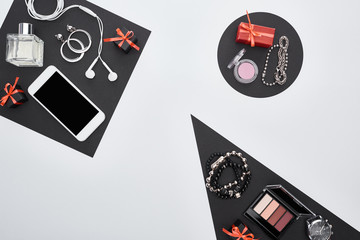 Obraz premium top view of gadget, gift boxes, perfume, bracelets, decorative cosmetics, earrings, earphones