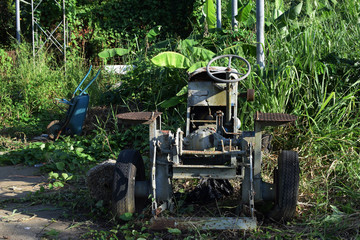 Wasted dilapidated rustic old farm tractor left on the vicinity of agricultural college campus