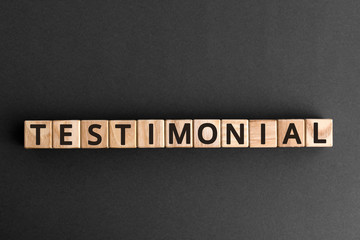 Testimonial - word from wooden blocks with letters,a statement about the character or qualities testimonial concept,  top view on grey background