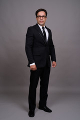 Full body shot of handsome Persian businessman in suit