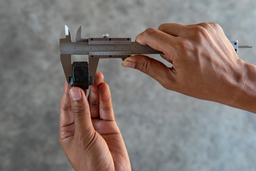 Using Vernier caliper to measure the dimensions of the nut.