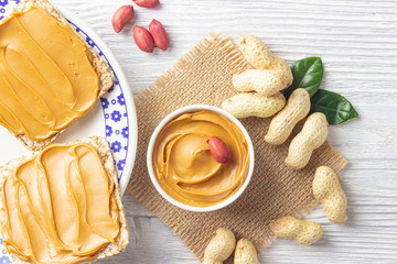 Peanut butter or paste on white wooden background.