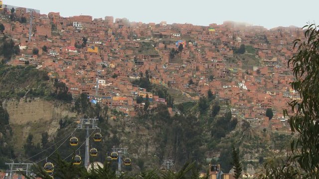 Poor hill suburbs view with yellow public cableway time lapse in cloudy windy day in La Paz, Bolivia