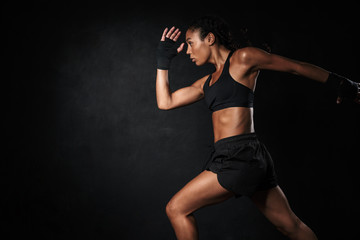Fototapeta na wymiar Image of african american woman in sportswear and hand wraps running