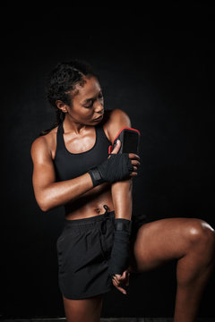 Image of athletic african american woman using mobile hand case