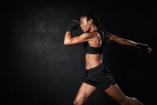 Image of young african american woman in sportswear and hand wraps running
