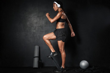 Image of african american woman doing workout with expander equipment