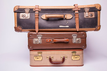 Old, retro, suitcases lie on the table with white background