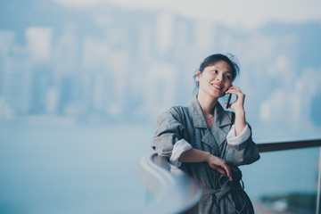 Fototapeta premium Woman wear bathrobe using smartphone on balcony 