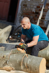 Strong farmer with chainsaw