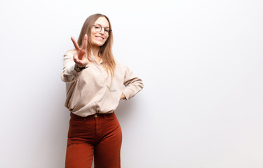 young pretty woman smiling and looking friendly, showing number two or second with hand forward,...