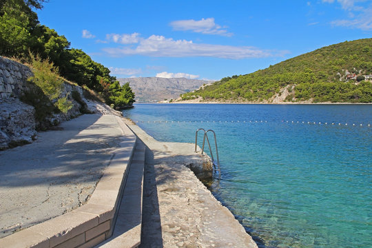 Beautiful landscape of sea Coast of Adriatic sea with a promenade and transparent blue water in Pucisca, Croatia. Island of Brac summertime.
