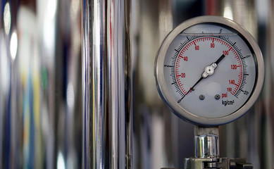 View of analog meter ,steel pipes and industrial process equipment background                  