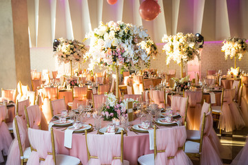 Beautiful dinner table decorated by gold accessories and flowers. Wedding. Decor