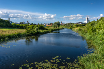 Fototapeta na wymiar Russia, Vladimir Oblast, Suzdal: Panorama with river Kamenka, blue sky, famous old Saviour Monastery of Saint Euthymius and Alexandrovsky Convent in the center of one of the oldest Russian towns.