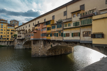 Side view of medieval stone bridge Ponte Vecchio over the Arno River in Florence, Tuscany, Italy.