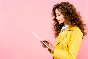 beautiful curly woman using digital tablet, isolated on pink