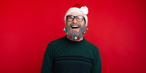 Photo of happy smiling man with decorated beard standing over red background