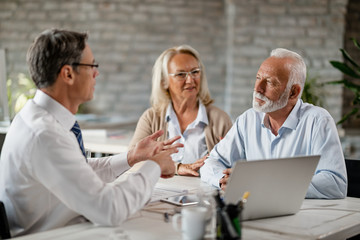 Senior couple talking to financial advisor on a meeting in the office.