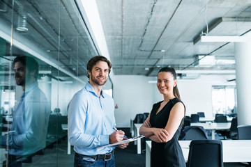 Young businesspeople with clipboard in an office, working.
