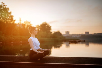Girl practice yoga early morning on pier