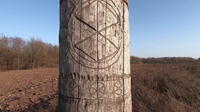 Wooden idol Slavic god Perun on a background of blue sky