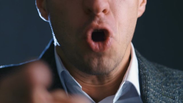 Close-up of angry boss scolding and shouting at employees threatening with a finger and shouting aggressively at the camera.