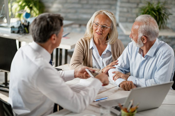 Senior woman and her husband having a meeting with financial advisor in the office.