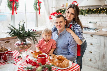 Authentic family with little daughter at the kitchen during Christmas morning