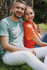 Beautiful couple sitting on the grass and smiling